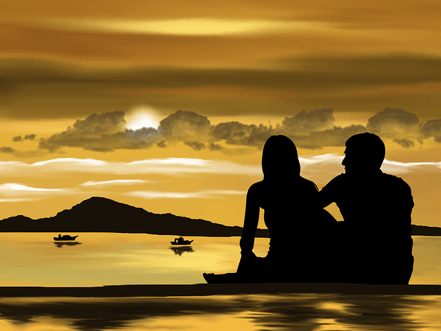 Para siedzi nad brzegiem jeziora i podziwia zachód słońca