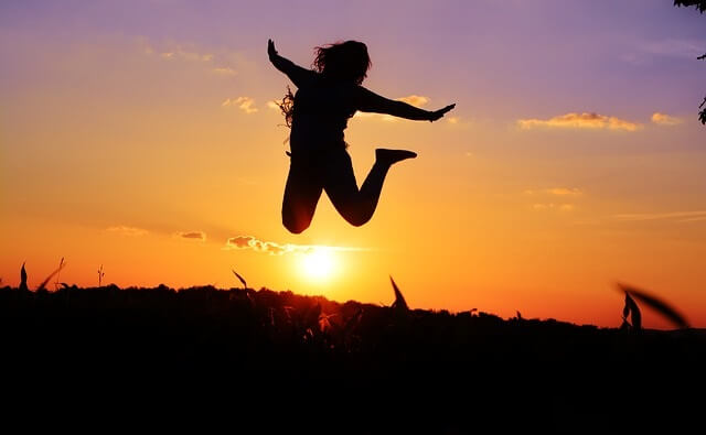 Sylwetka skaczącej radosnej kobiety