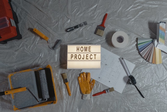 Lampa z napisem home project, obok przybory malarskie